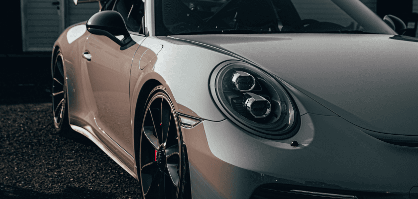 A close-up view of a sleek, silver sports car highlighting its distinctive headlights and alloy wheels. A close-up view of a sleek, silver sports car highlighting its distinctive headlights and alloy wheels.