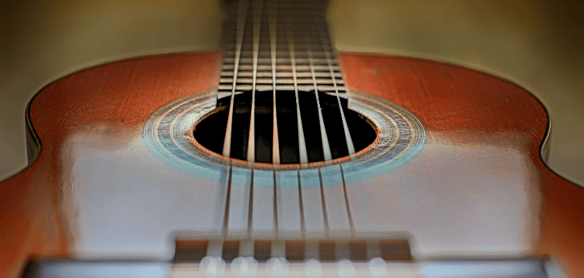 Close-up view of an acoustic guitar's body and strings.