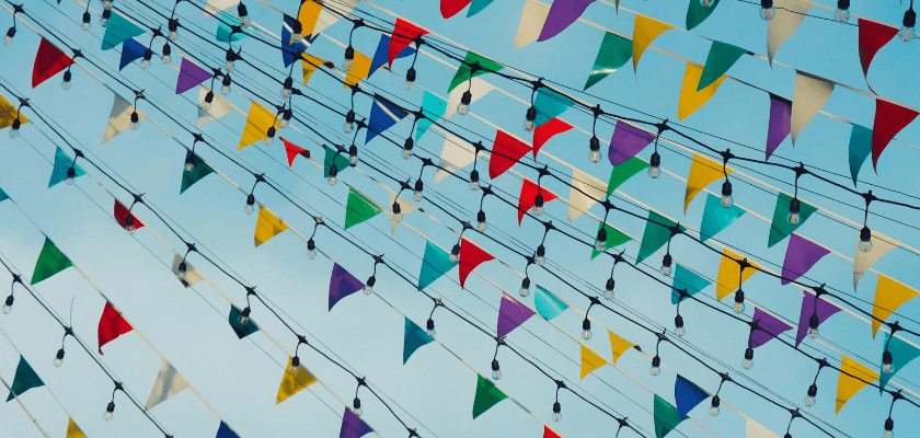 Colorful triangular flags strung across a blue sky. Colorful triangular flags strung across a blue sky.