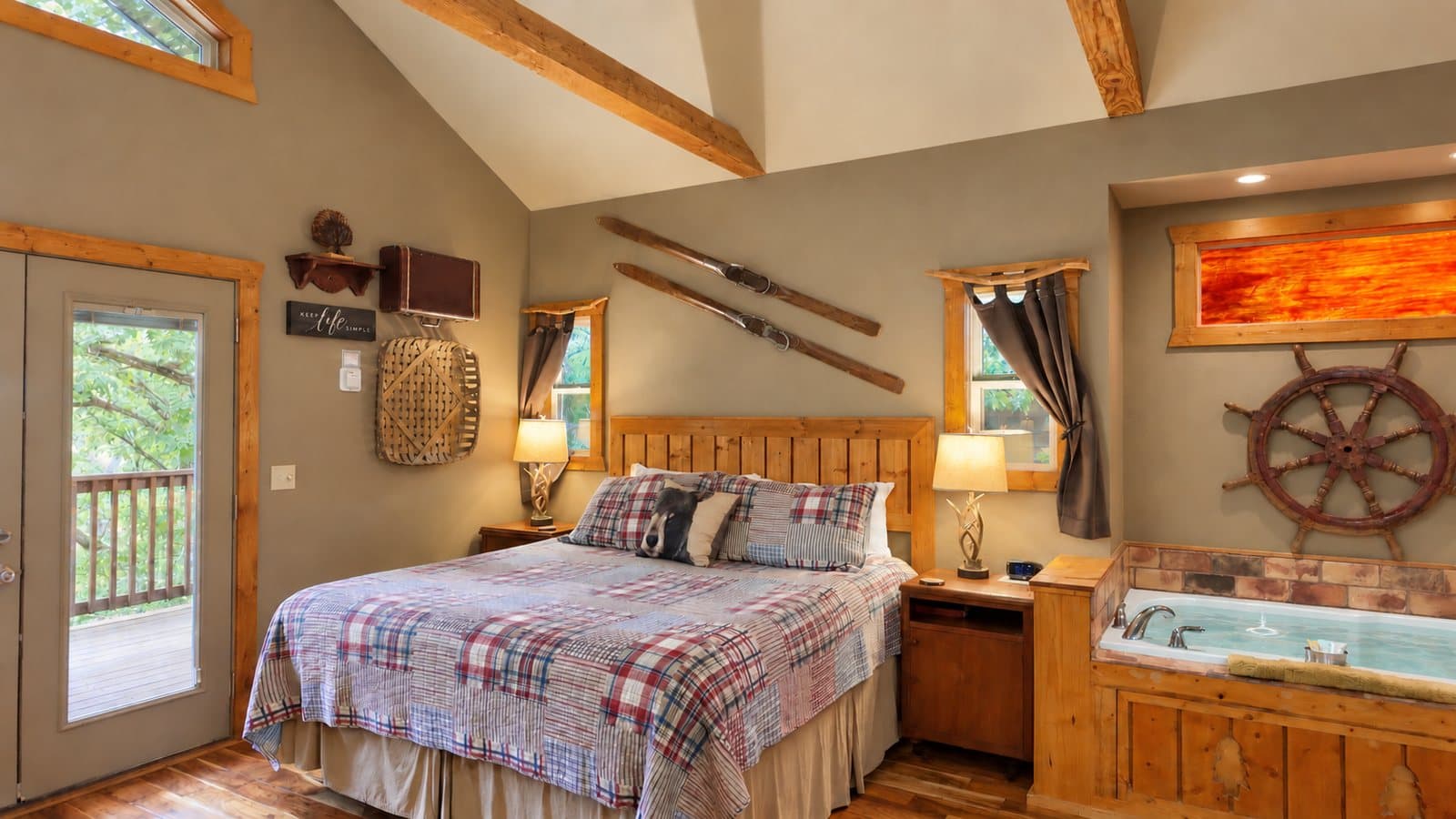 Cozy bedroom with a wooden bed, decorative elements, and a small jacuzzi tub.