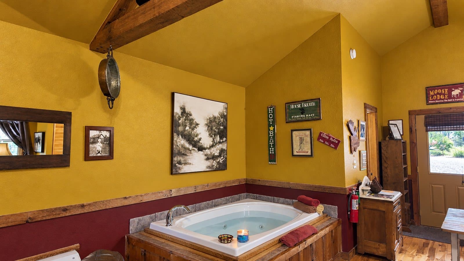 A cozy bathroom featuring a large hot tub, yellow walls, and rustic decor.