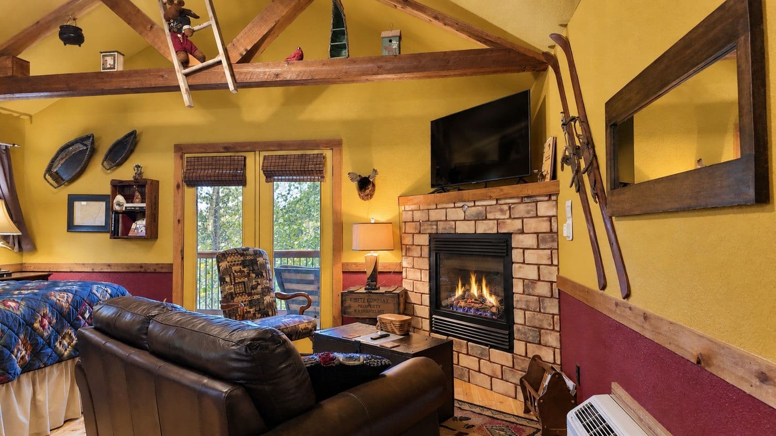 Cozy living room with a fireplace, wooden accents, and large windows.
