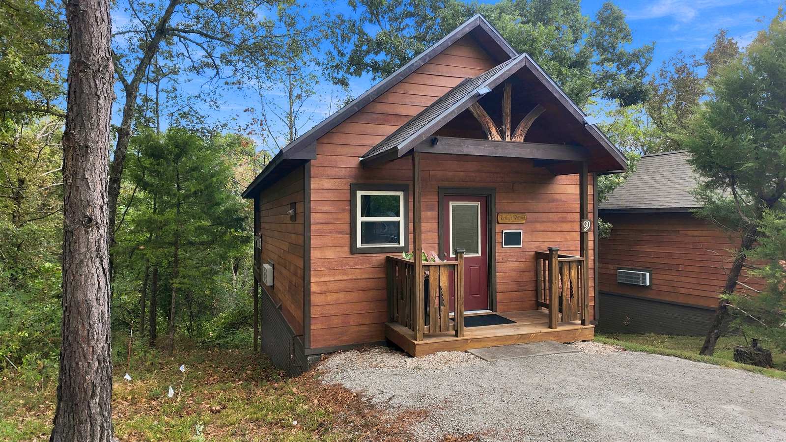 A small wooden cabin surrounded by trees.