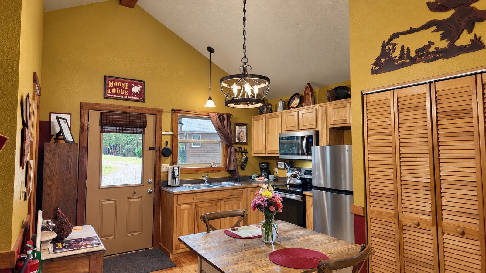 A cozy kitchen with wooden cabinets, a dining table, and warm yellow walls.