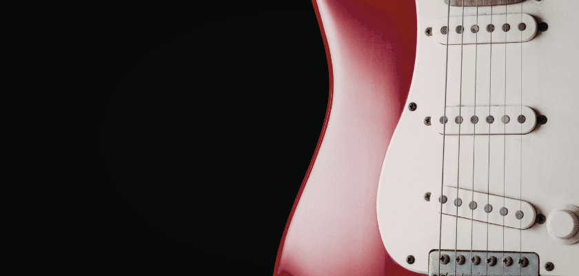 Close-up of a red electric guitar against a black background.