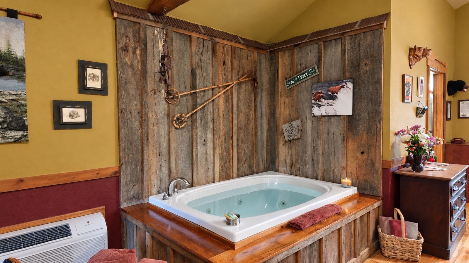 A rustic bathroom featuring a white hot tub surrounded by wooden walls and decor.
