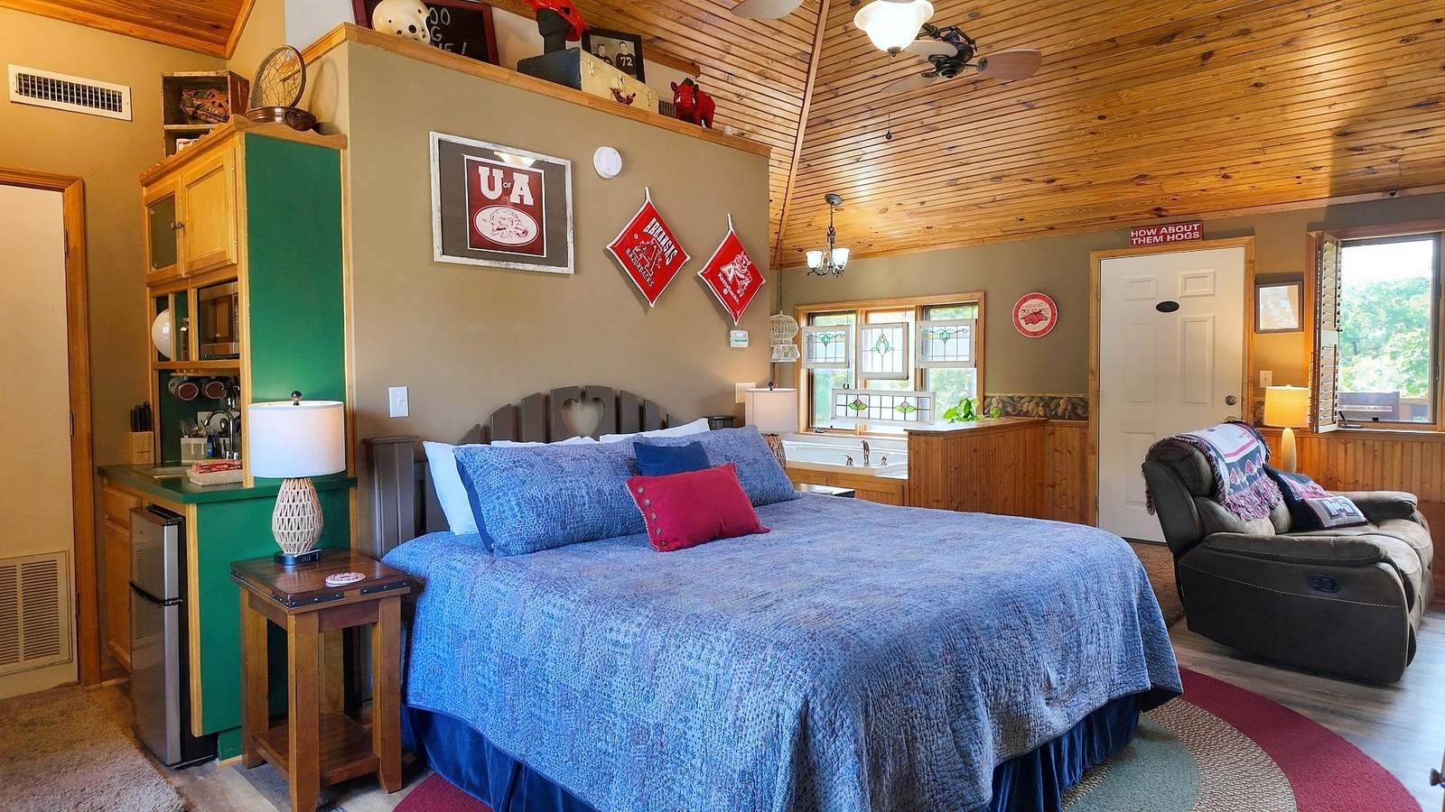 Cozy bedroom with a large bed, rustic decor, and a warm wooden ceiling.