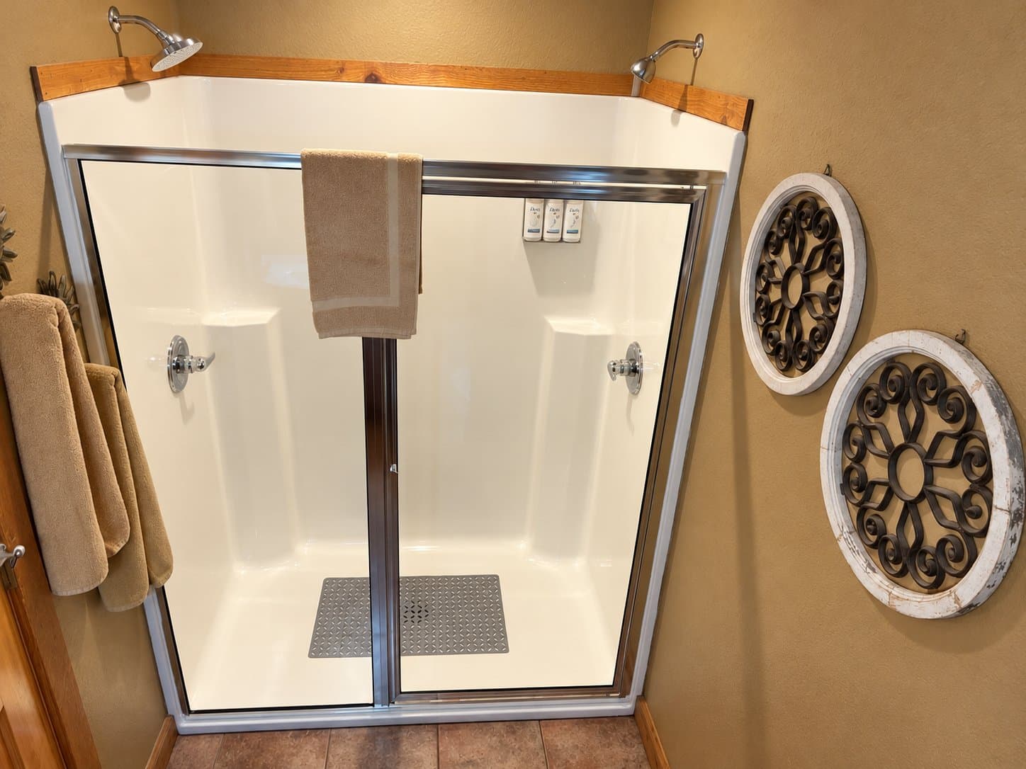 A clean and modern shower with glass doors and decorative wall accents.
