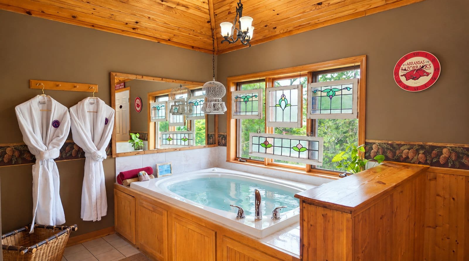 A cozy bathroom featuring a large hot tub, wooden accents, and stained glass windows.