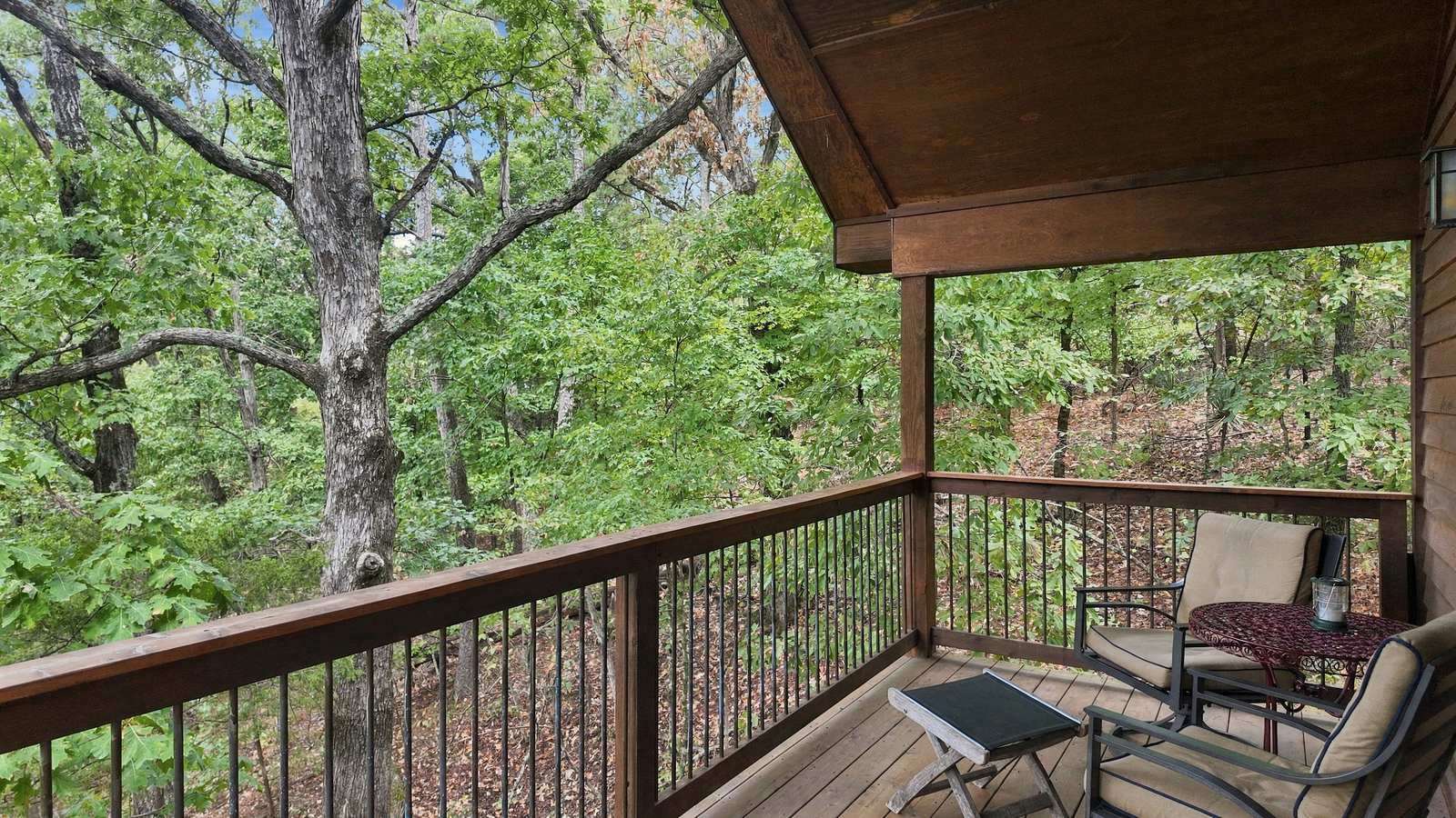 A cozy balcony overlooking a lush forest.