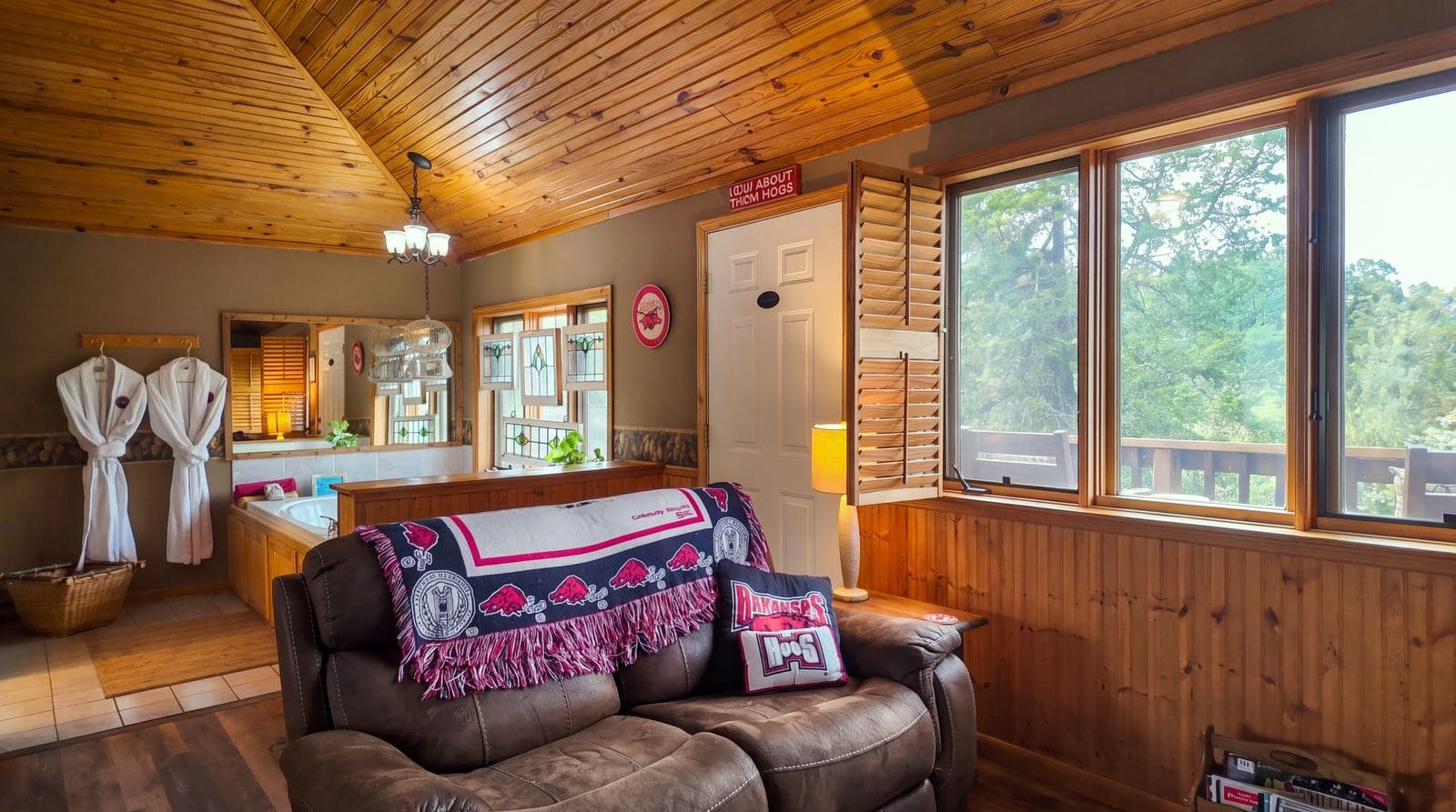 Cozy living area featuring wooden finishes, a comfortable sofa, and large windows with outdoor views.